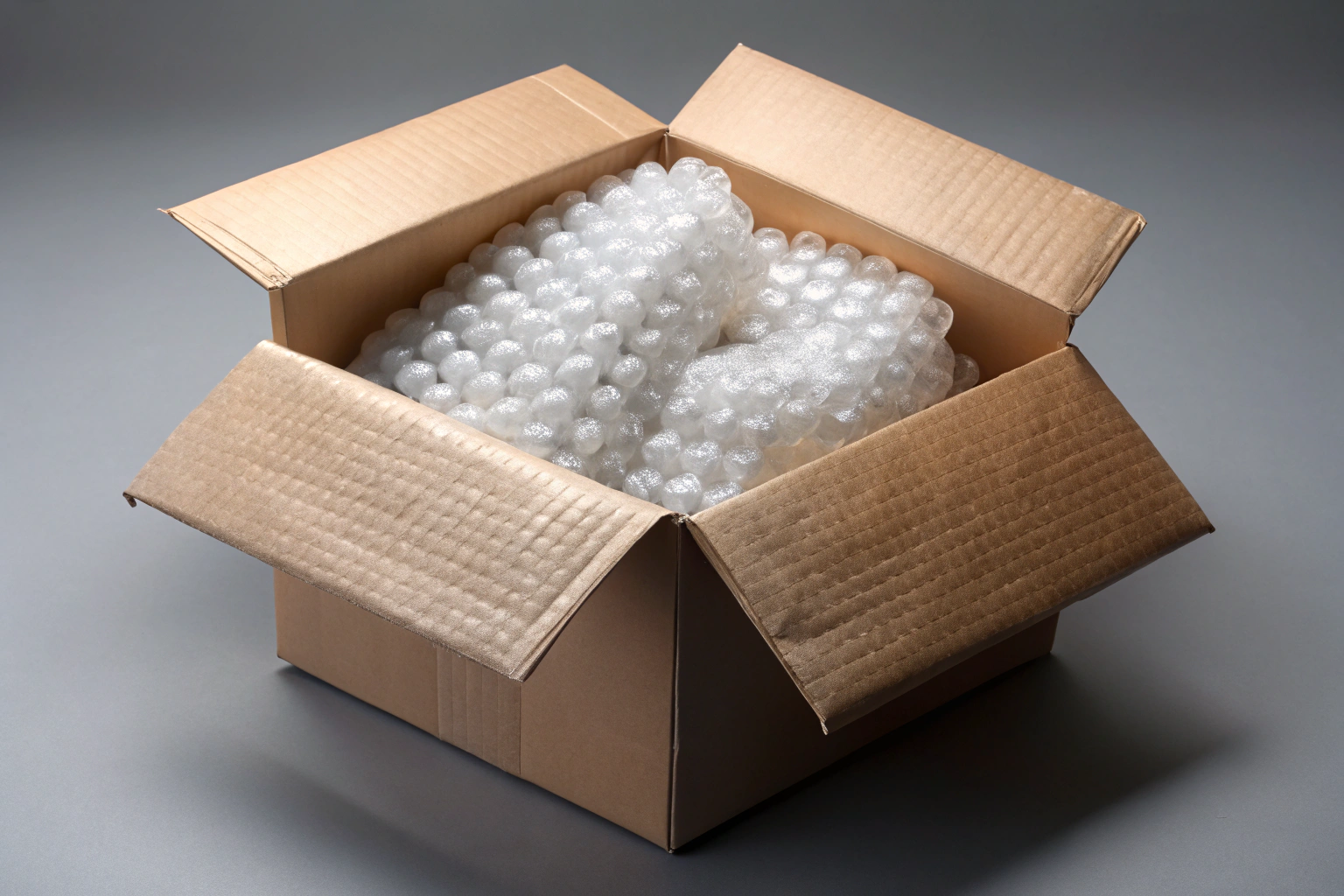 Boîte en carton ouverte avec du matériel d emballage comme du papier bulle, posée sur une surface neutre, évoquant la préparation soignée d un envoi